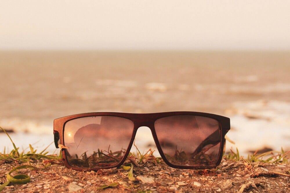 sunglasses on grass Newly repaired square-frame sunglasses sitting on a patch of grass near the coastline under a soft warm sky