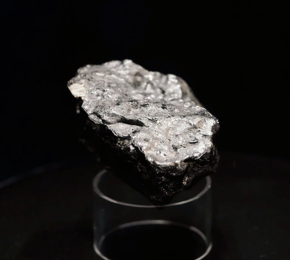 Raw titanium mineral ore on a black background representing durable metal eyeglass frame materials